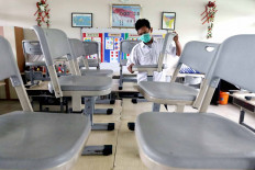 A school custodian arranges desks and chairs in a classroom at SD Bendungan Hilir 05 Pagi state elementary school in Central Jakarta on June 22. The classroom is cleaned twice a week to comply with COVID-19 health protocols. JP/Dhoni Setiawan