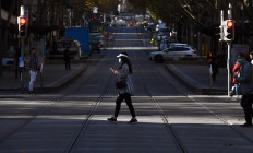 A woman crosses a street in Melbourne's central business district on June 17, 2020, as more Australians return to the city centre with a relaxing of the COVID-19 coronavirus rules.
