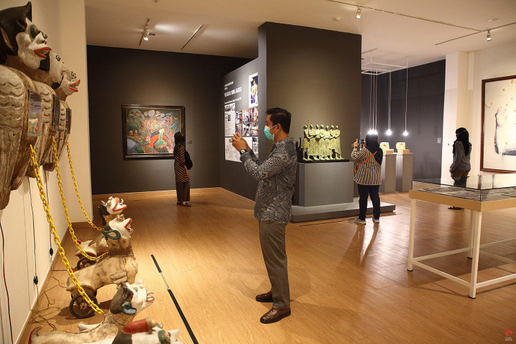 Keeping distance: Visitors with masks on observe artwork in the permanent exhibition room of the National Gallery in Jakarta.