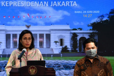 Hard cash: Finance Minister Sri Mulyani Indrawati (left) and State-Owned Enterprises Minister Erick Thohir announce the government’s placement of Rp 30 trillion (US$2.12 billion) in state banks on June 24. The funds will be channeled as loans to businesses to boost the real sector.
