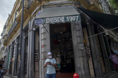 A man wearing a face mask leaves the centenary bar Armazem Senado in Rio de Janeiro, Brazil, on July 2, 2020 as the city's bars and restaurants reopened after more than three months of lockdown to fight the COVID-19 novel coronavirus pandemic. 
