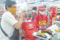 Say no to plastic: A shopper uses a reusable bag at a supermarket in Yogyakarta. Many shopping centers in the city no longer offer single-use plastic bags.