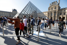 Visitors queue in front of the Louvre Pyramid designed by Chinese-born U.S. architect Ieoh Ming Pei in Paris as the museum reopens its doors to the public after almost 4-month closure due to the coronavirus disease (COVID-19) outbreak in France, July 6, 2020. 