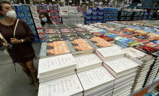 A woman looks over at copies of the book(R) 'The Room Where it Happened' a memoir by John Bolton at Costco in Marina del Rey, California on June 23, 2020. 