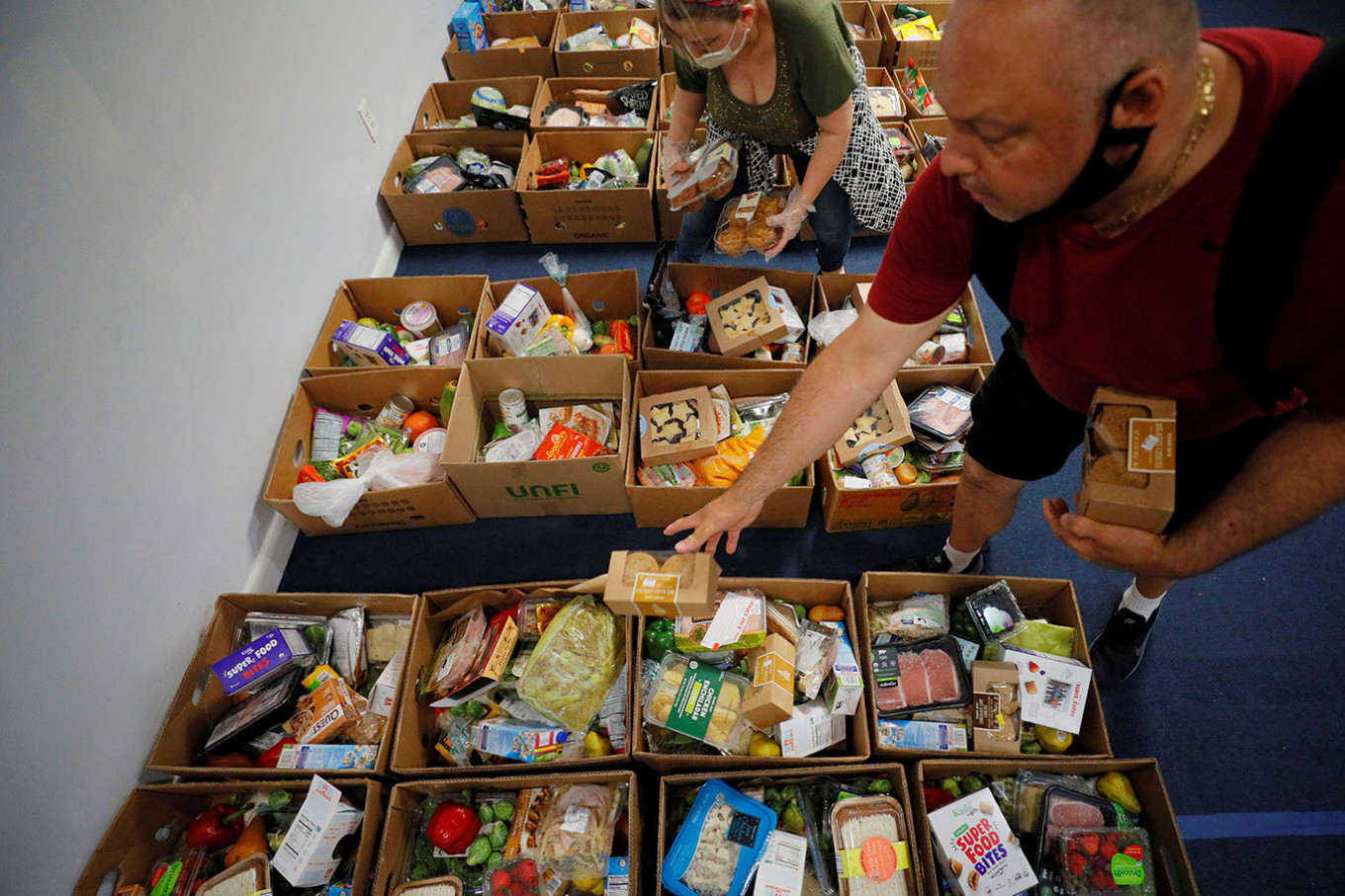 Volunteers prepare boxes of food to be given away at a food pantry run by Revival International Center (Centro Internacional de Avivamiento) Chelsea, amid ongoing economic hardship for some people due to the COVID-19 outbreak, in Chelsea, Massachusetts, U.S., July 6, 2020.   