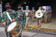Soldiers carry the coffin and portrait of Sgt. Maj. Rama Wahyudi at Halim Perdanakusuma Air Force Base in East Jakarta on July 3. Rama died on June 22 after being shot during his peacekeeping mission with the United Nations Organization Stabilization Mission in the Democratic Republic of the Congo (MONUSCO). JP/Dhoni Setiawan