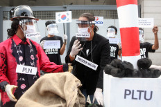 Activists from the Civil Society Coalition (Koalisi Masyarakat Sipil) stage a protest in front of the South Korean Embassy in Jakarta on June 30. The coalition opposed the construction of coal-fired power stations, known as the Java 9 and 10 PLTU, which they argued would damage the environment and people’s health with their "dirty energy". JP/Seto Wardhana
