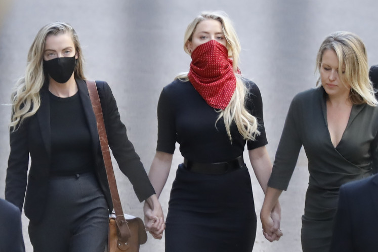 Amber Heard, (C), American actress and former wife of Hollywood actor Johnny Depp arrives on the first day of libel trial brought by Hollywood actor Johnny Depp against News Group Newspapers (NGN), at the High Court in London, on July 7, 2020. 
