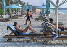 Tourists sunbathe at the beach of the Al Naseem hotel in the Gulf emirate of Dubai in the United Arab Emirates, on July 7, 2020. 