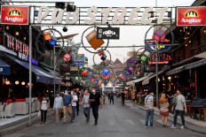 This picture taken on March 5, 2020 shows tourists wearing facemasks, amid fears of the spread of the COVID-19 novel coronavirus, as they walk along Pub Street in Siem Reap province. 