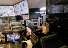 A staff member wearing a protective mask and gloves prepares food to deliver for a customer at a KFC fast food outlet in Colombo, Sri Lanka, July 9, 2020. 