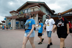 Summer Selmon, her brother Levi, and their parents Dave and Brandi wear face masks while visiting the Disney Springs shopping and dining district during their vacation at Walt Disney World during a phased reopening from coronavirus disease (COVID-19) restrictions in Lake Buena Vista, Florida, United States, on July 11, 2020. 