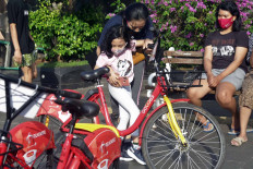 A girl prepares to ride a Gowes bicycle near the Hotel Indonesia traffic circle in Jakarta on July 5. Bike-sharing platform Gowes is providing 200 bicycles at six points in the city during its trial run. JP/Wendra Ajistyatama