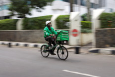 A Grabfood worker wearing a protective mask rides along a street, amid the COVID-19 outbreak, in Jakarta, on July 13, 2020. 