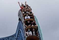 Visitors take a ride on a rollercoaster at the Toshimaen amusement park in Tokyo on July 13, 2020.

