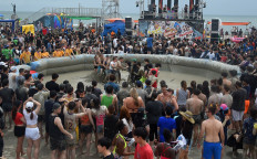 Tourists play in a mud pool during the 22th Boryeong Mud Festival at Daecheon beach in Boryeong on July 20, 2019.