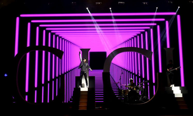 Digital sync: Armand Maulana (center) of pop rock band Gigi performs at a 2019 concert in Jakarta. Musicians have turned to digital platforms to stay relevant and connect with fans during the health crisis.