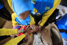 Health workers administer drops of the polio vaccine to children under 5 at an integrated health service post (Posyandu) Jati 2 in Gunung Kelurahan, Kebayoran Baru, South Jakarta, on March 8, 2016.