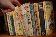 Book dealer Jon Gilbert poses with a full collection of first edition copies of Ian Fleming's James Bond books during the Chelsea Antiquarian Book Fair in London on November 2, 2012. 