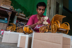 A craftsman completes a miniature bamboo becak (pedicab) in Cimangenteung village in Lebak, Banten, on July 8. Banks are offering unsecured loans for small-scale enterprises and other borrowers.