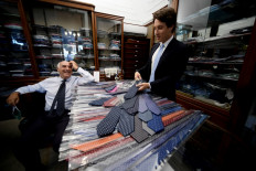 Maurizio Marinella (left) and his son Alessandro work in the 'E. Marinella' shirt and tie makers family business shop in Naples on June 30, 2020. 