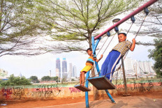 Hanging on: Children play on swings at a playground near the West Flood Canal in Jakarta on Tuesday. Save the Children has
said around 9.7 million children across the world are at risk of permanently dropping out of school due to school closures during
the COVID-19 pandemic.