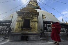 A Buddhist monk walks at the Swayambhunath Stupa in Kathmandu on July 13, 2020.
