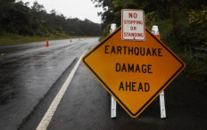  A sign is posted warning of earthquake damage to the road from seismic activity at the Kilauea volcano on Hawaii's Big Island on May 17, 2018 in Hawaii Volcanoes National Park, Hawaii. 