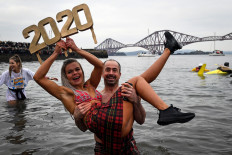 Participants pose in the water as they take part in the annual New Year's Day 'Loony Dook' swim, in the Firth of Forth, in South Queensferry, near Edinburgh, on January 1, 2020. 