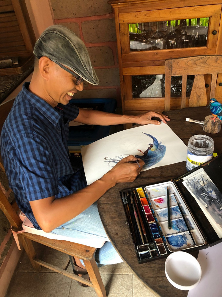 Aluysius Sulistianta works on a design using watercolors.