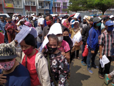 People queue to receive government social cash transfers (BST) at an office complex in Cibinong, Bogor regency, on July 20. The Social Affairs Ministry is working with post offices to channel the financial assistance to underprivileged residents from May until July. Each recipient will receive Rp 600,000 (US$42) per month. JP/P.J. Leo