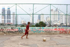 A boy plays soccer at a playground near the West Flood Canal in Jakarta on July 21. London-based NGO Save the Children states that around 9.7 million children around the world have potentially been affected by school closures and are at risk of permanently dropping out of school because of the COVID-19 pandemic. JP/Seto Wardhana