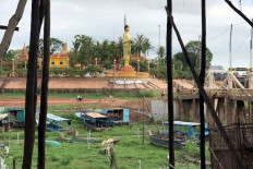 A Buddha statue overlooks docked scattered boats on a dried up tributary that connects to the Tonle Sap lake in Kampong Khleang, Cambodia July 6, 2020.