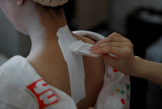Koiku paints the back of Mayu's neck, both of whom are geisha, as they get ready at Ikuko's home to work at a party being hosted by customers at a restaurant, where they will be entertaining with other geisha, during the coronavirus disease (COVID-19) outbreak, in Tokyo, Japan, June 23, 2020.  Reuters/Kim Kyung-Hoon 