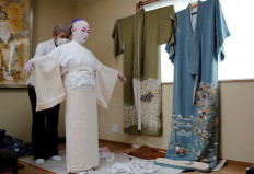 Shoichi Sanagashi, a kimono dresser, wears a protective face mask as he dresses Tokijyo Hanasaki, a jiutamai dancer, before Hanasaki is recorded dancing for a film supported by the Tokyo Metropolitan government in order to support artists during the coronavirus disease (COVID-19) outbreak, at a studio in Tokyo, Japan, June 29, 2020. Reuters/Kim Kyung-Hoon 