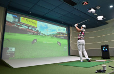 This photo taken on July 24, 2020 shows a South Korean golfer hitting a ball in a simulation booth during the GTour screen golf tournament in Daejeon, south of Seoul. 
