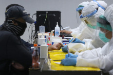 Medical workers take blood from passengers for a rapid COVID-19 test at Terminal 3 of Soekarno-Hatta International Airport in Banten, Tangerang, on July 29.