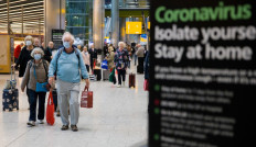 Travelers who had been aboard the Braemar cruise ship and wearing face masks as a precautionary measure against COVID-19 react as they arrive at Heathrow Airport in London on March 19, 2020. 