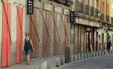 A woman wearing a protective mask walks past closed restaurants, amid the coronavirus disease (COVID-19) outbreak, in Madrid, Spain, July 31, 2020. 