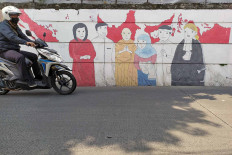 Tolerance: A motorcyclist passes a mural depicting representatives of multiple religions in Cinere, Depok, West Java, on July 29, 2020.