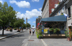 Tourists walks down Place Jacques-Cartier in Old-Montreal, Canada on July 28, 2020. 