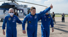 This handout photo released courtesy of NASA shows NASA astronaut Robert Behnken giving a thumbs up to onlookers as he boards a plane at Naval Air Station Pensacola to return him and NASA astronaut Douglas Hurley home to Houston a few hours after the duo landed in their SpaceX Crew Dragon Endeavour spacecraft off the coast of Pensacola, Florida on August 2, 2020. 