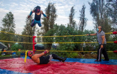 Wrestlers perform during the Chinampalucha event organized by Mexican wrestlers in the chinampas of Xochimilco in Mexico City, on August 1, 2020, as rings remain closed due to the COVID-19 coronavirus pandemic. 