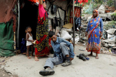 Mansoor Khan, 44, who works as a waste collector, puts on his shoes as he gets ready to look for recyclable materials from a landfill site next to his house, during the coronavirus disease (COVID-19) outbreak, in New Delhi, India, July 16, 2020. Reuters/Adnan Abidi 