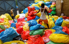 A waste collector walks over disposed medical waste bags inside a rubbish dump outside a hospital, during the coronavirus disease (COVID-19) outbreak, in New Delhi, India, July 17, 2020. Reuters/Adnan Abidi 