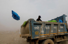 A waste collector goes through bags of rubbish as he throws them off the truck into the landfill site, during the coronavirus disease (COVID-19) outbreak, in New Delhi, India, July 15, 2020. Reuters/Adnan Abidi 