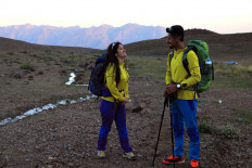 Newlyweds Iraqi Kurds Salar Chomany, 34, and Soma Mohammed, 28, walk together during a trekking ceremony at Mount Halgurd, in Iraq's autotomous Kurdistan region, on the first day of their honeymoon, on August 2, 2020. 