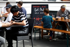 People sit at a restaurant on the opening day of 'Eat Out to Help Out' scheme, amid the coronavirus disease (COVID-19) outbreak, in Manchester, Britain, on August 3, 2020. 