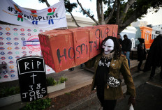 A worker of the hospitality industry carries a mock coffin outside a closed bar during a protest against the coronavirus disease (COVID-19) lockdown regulations and job losses in Cape Town, South Africa, August 6, 2020. 