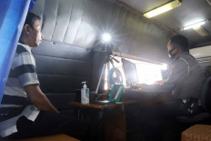 Going local: A police officer takes a photo of a resident seeking to extend his driver’s license on Friday in Pamulang, South Tangerang, Banten. The Jakarta Traffic Police has opened services to extend driver’s licenses after a pandemic-induced suspension.